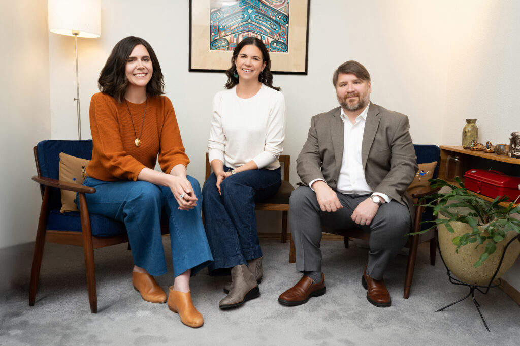 photo of the three mediators, seated in cozy office, smiling at the camera